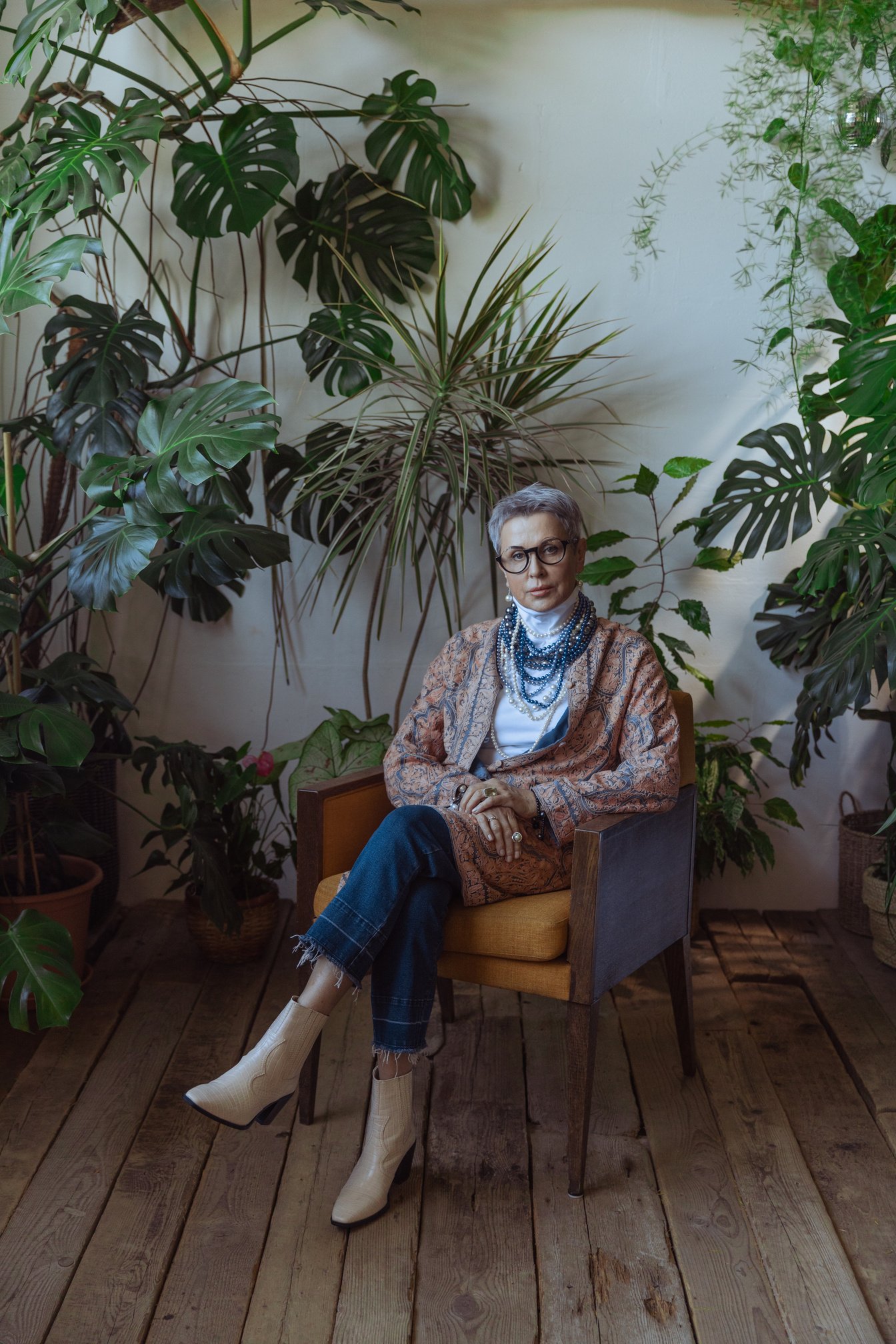 an individual sitting in a chair surrounded by plants