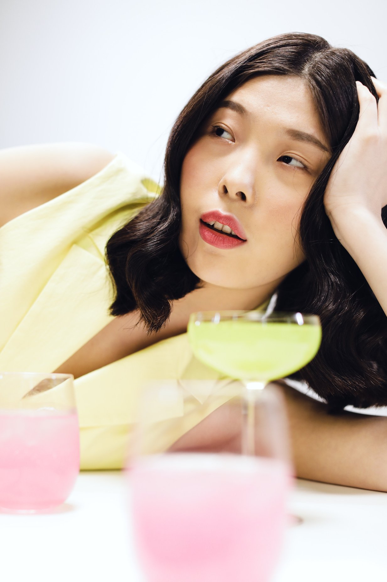 a person laying on a table with a drink in front of them.